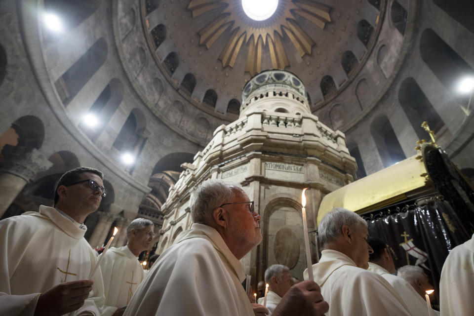 Catholic clergy walk holding candles during the Holy Thursday procession at the Church of the Holy Sepulcher, the site where according to tradition Jesus was crucified and buried, in the Old City of Jerusalem, Thursday, April 6, 2023. (AP Photo/Maya Alleruzzo)