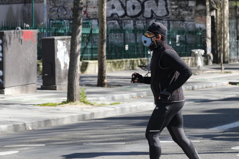 PARIS, FRANCE - MARCH 25: A man wears a medical mask within precautions against coronavirus as he runs in a street in Paris, France on March 25, 2020. (Photo by Geoffroy Van Der Hasselt/Anadolu Agency via Getty Images)