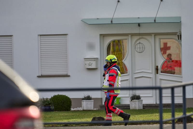 A paramedic walks near the incident area. According to the police, three people, including a child, were killed in an act of violence in a residential area. Emergency services discovered the suspected perpetrator seriously injured after entering the building, according to a police spokesperson. Sascha Ditscher/dpa