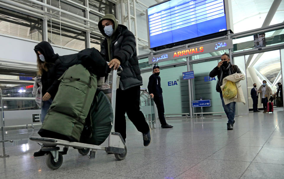 Iraqi migrants arrive to the airport in Irbil, Iraq, early Friday, Nov. 26, 2021. 170 Iraqi nationals returned home Friday from Belarus in a repatriation process that came after tensions at Poland's eastern border, where thousands of migrants became stuck in a cold and soggy forest. (AP Photo/Hussein Ibrahim)