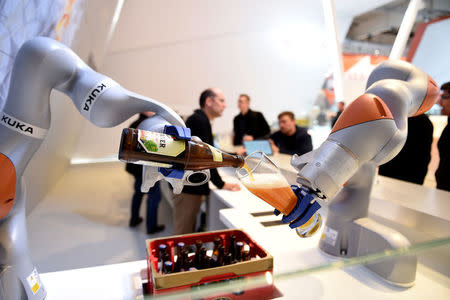 FILE PHOTO: Robots at the Kuka stand pour a beer into a glass at the Hannover Messe industrial trade fair in Hanover, Germany April 23, 2016. REUTERS/Nigel Treblin/File Photo