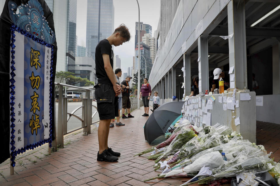 A man pays respect on the site where a man fell to his death a day earlier after hanging a protest banner against the extradition bill on the scaffolding of a shopping mall in Hong Kong, Sunday, June 16, 2019. Hong Kong was bracing Sunday for another massive protest over an unpopular extradition bill that has highlighted the territory's apprehension about relations with mainland China, a week after the crisis brought as many as 1 million into the streets. (AP Photo/Vincent Yu)