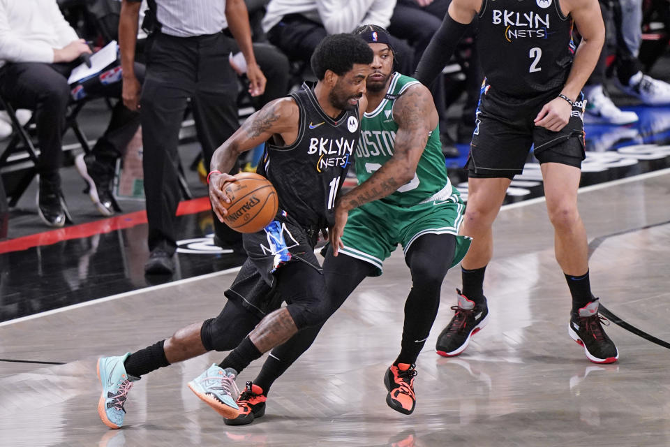 Brooklyn Nets guard Kyrie Irving drives around Boston Celtics guard Marcus Smart.