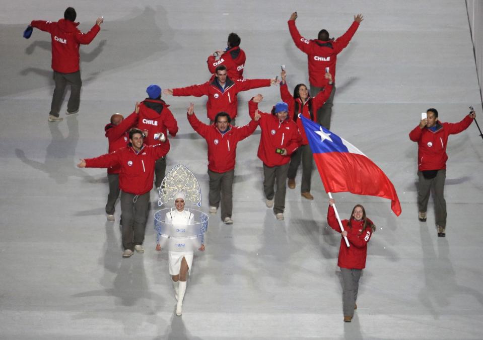 Dominique Ohaco of Chile waves her national flag and enters the arena with teammates during the opening ceremony of the 2014 Winter Olympics in Sochi, Russia, Friday, Feb. 7, 2014. (AP Photo/Charlie Riedel)