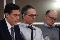 Tad Deluca, center, listens as attorney Parker Stinar addresses the media during a news conference, Thursday, Feb. 27, 2020 in Southfield, Mich. Deluca, a University of Michigan wrestler from the 1970s, says he was kicked off the team and lost his financial aid after complaining to a coach that he had been abused by a sports doctor. Deluca identified himself as the whistleblower whose 2018 complaint about the late Dr. Robert E. Anderson led to a police investigation. (AP Photo/Carlos Osorio)