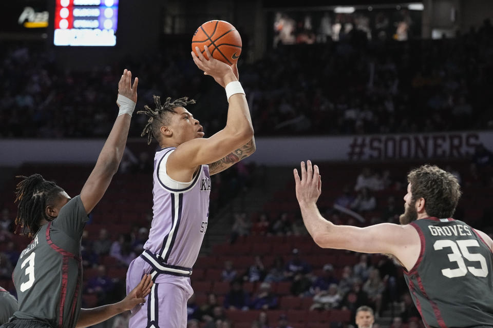 Kansas State forward Keyontae Johnson, center, shoots between Oklahoma guard Otega Oweh and forward Tanner Groves (35) in the first half of an NCAA college basketball game Tuesday, Feb. 14, 2023, in Norman, Okla. (AP Photo/Sue Ogrocki)