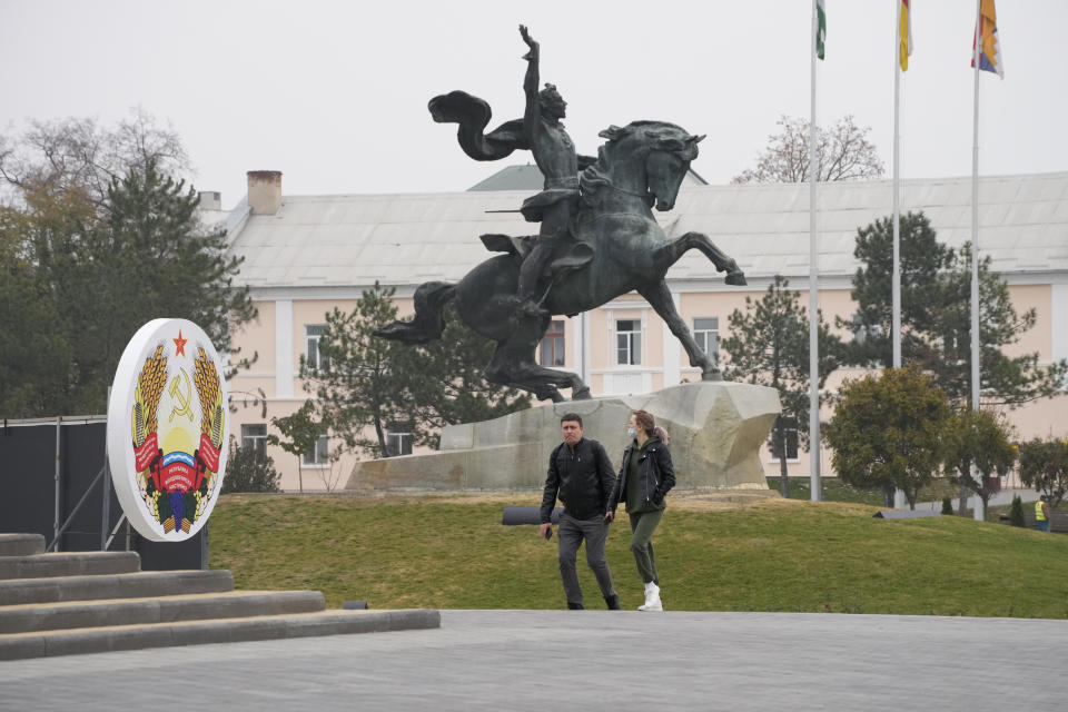 FILE - People walk past the equestrian statue of a Russian Generalissimo Alexander Suvorov in Tiraspol, , the capital of the Russia-backed breakaway region of Transnistria, in Moldova on Nov. 1, 2021. Since Russia fully invaded Ukraine two years ago, a string of incidents in neighboring Moldova's Russia-backed breakaway region of Transnistria have periodically raised the specter that European Union candidate Moldova could also be in Moscow's crosshairs.(AP Photo/Dmitri Lovetsky, File)