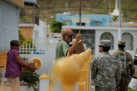 A resident tells members of the Puerto Rican National Guard the location of a woman who needs help as recovery efforts continue following Hurricane Maria in Ceiba, Puerto Rico, October 4, 2017. REUTERS/Lucas Jackson