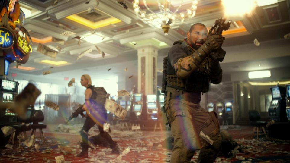 Dave Bautista aims a gun in a casino in a still from Army of the Dead.