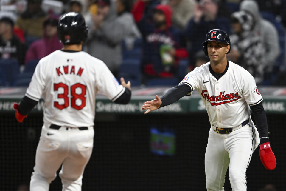 Cleveland Guardians' Steven Kwan (38) and Brayan Rocchio celebrate scoring on a single by Andrés Giménez during the fifth inning of the team's baseball game against the Oakland Athletics, Friday, April 19, 2024, in Cleveland. (AP Photo/Nick Cammett)