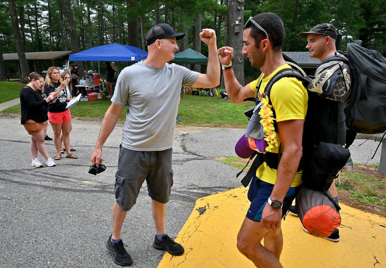 Barre Falls Dam aid station volunteer Dan Giza of Worcester high-fives ruckers as they arrive.