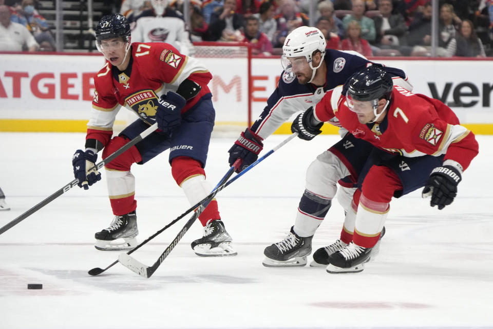 Columbus Blue Jackets center Sean Kuraly, center, Florida Panthers defenseman Dmitry Kulikov, right, and center Evan Rodrigues (17) battle for the puck during the first period of an NHL hockey game, Monday, Nov. 6, 2023, in Sunrise, Fla. (AP Photo/Wilfredo Lee)