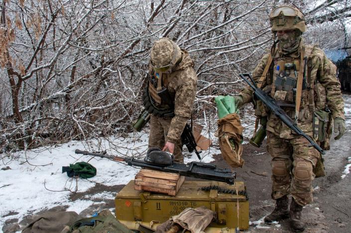 Two Ukrainian soldiers outside Karkhiv in a snowy environment with bare trees, on February 26, 2022.