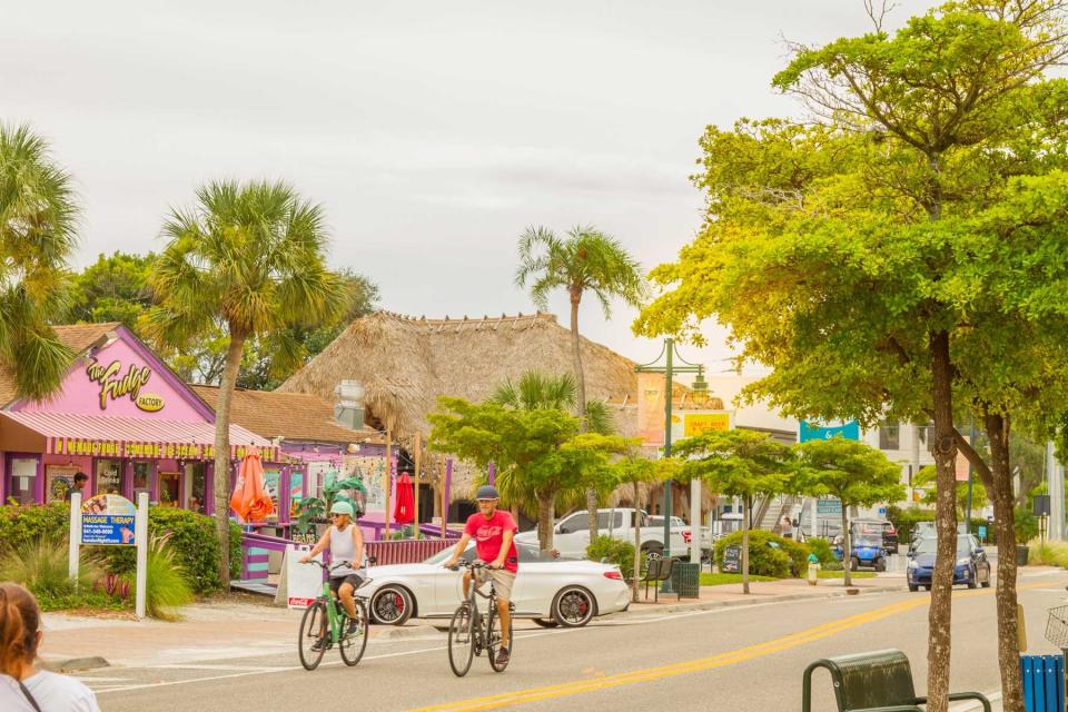 Two people ride bikes down the road in Sarasota, Florida