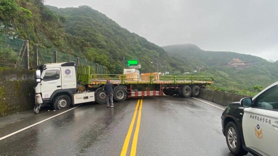 載運電纜線的曳引車自撞山壁，整輛車橫卡在路中央，佔據全線車道。（圖／瑞芳分局提供）