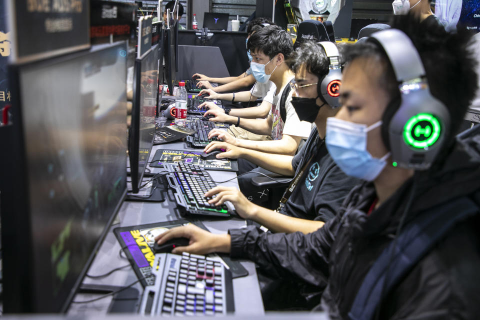 SHANGHAI, CHINA - JULY 31: People play online games at the booth of Huya, a Chinese live-streaming platform for video games and e-sports, during the 19th China Digital Entertainment Expo & Conference (ChinaJoy) at Shanghai New International Expo Centre on July 31, 2021 in Shanghai, China. (Photo by VCG/VCG via Getty Images)