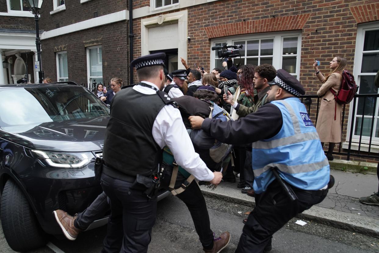 Police officers move a man trying to block Labour leader Sir Keir Starmer's car as he leaves, following his speech on the situation in the Middle East at Chatham House in central London. Picture date: Tuesday October 31, 2023.