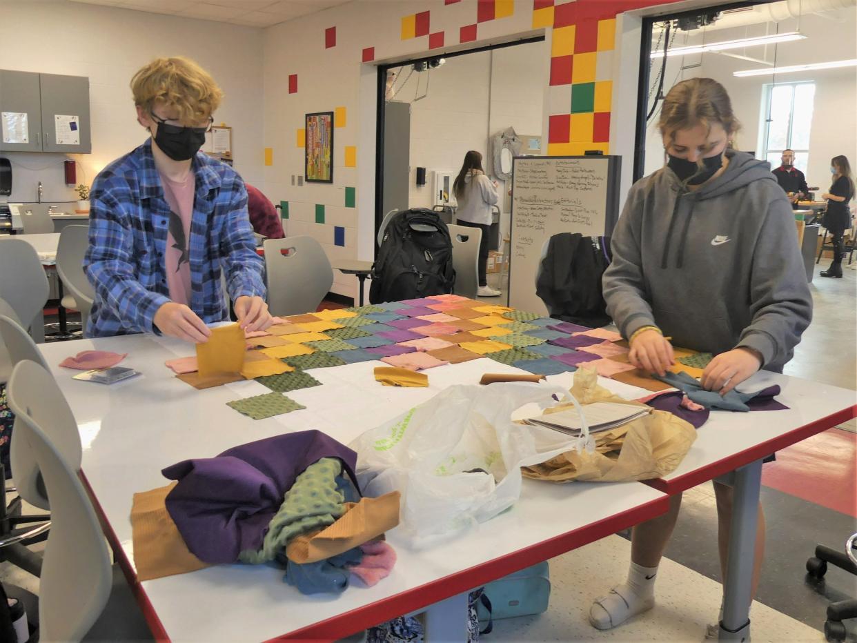 Gabriel Campbell and Ava Norton, eighth graders at Edgewood Junior High School, lay out squares of fabric Nov. 18 in the school's design lab.