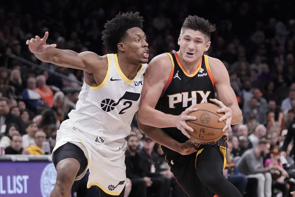 Phoenix Suns' Grayson Allen, right, drives to the basket against Utah Jazz's Collin Sexton (2) during the second half of an NBA basketball game in Phoenix, Thursday, Jan. 8, 2024. Phoenix won 129-115. (AP Photo/Darryl Webb)