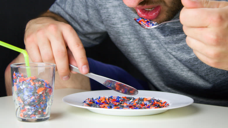 person eating tiny plastic pieces