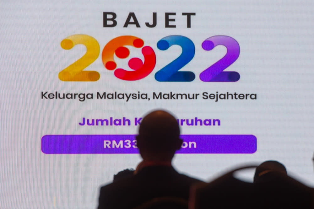 Government servants watch Finance Minister Datuk Seri Tengku Zafrul Abdul Aziz speaking during the tabling of Budget 2022 in the Dewan Rakyat, October 29, 2021. — Picture by Shafwan Zaidon
