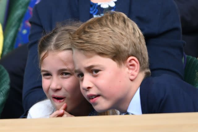 <p>Karwai Tang/WireImage</p> Princess Charlotte and Prince George lean in for a closer look at the Wimbledon Court on July 16.