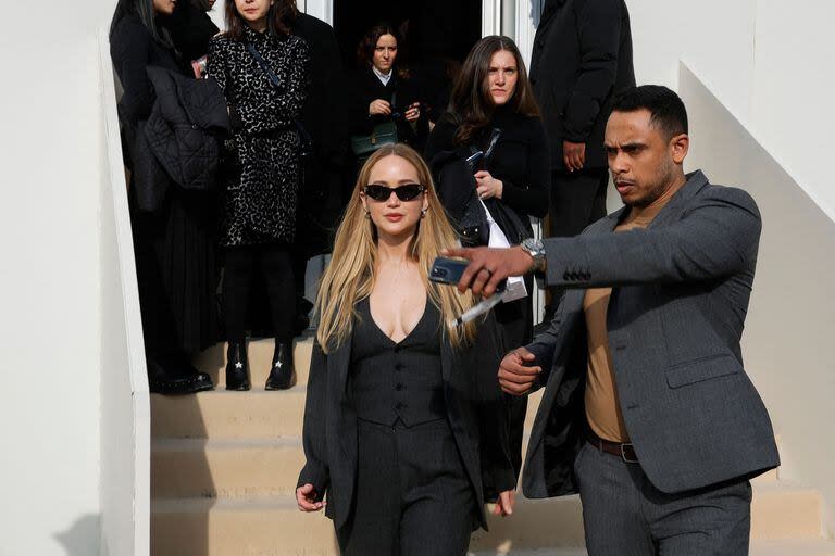 Jennifer Lawrence también dije presente en la Semana de la Moda de París. La protagonista de Los juegos del hambre fue una de las invitadas especiales del desfile de la firma Christian Dior. Lawrence optó por la sobriedad y eligió llevar un traje sastre de tres piezas gris sin nada debajo. Completó el look con el pelo suelto, cartera Lady Dior y unos lentes de sol ovalados

