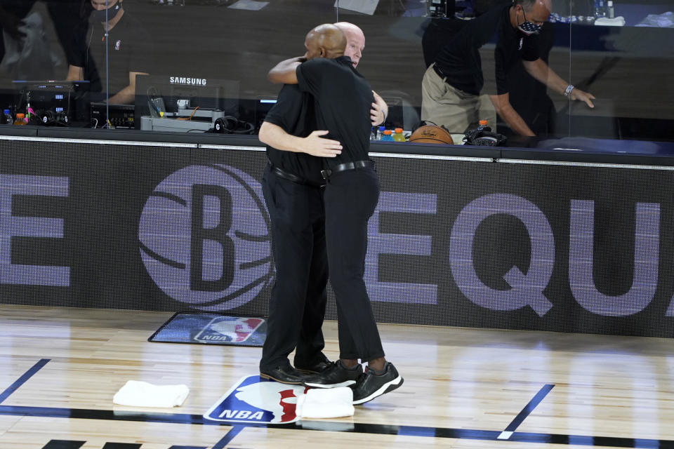 Orlando Magic head coach Steve Clifford, left, and Brooklyn Nets head coach Jacque Vaughn hug before the start of an NBA basketball game Friday, July 31, 2020, in Lake Buena Vista, Fla. (AP Photo/Ashley Landis, Pool)