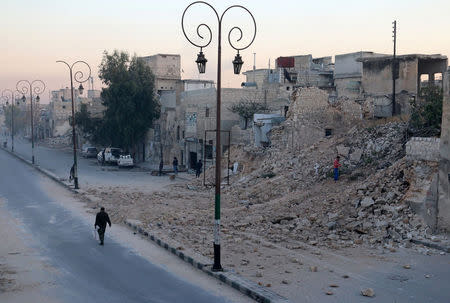 A man walks past a damaged site in the rebel-held besieged Qadi Askar neighbourhood of Aleppo, Syria November 24, 2016. REUTERS/Abdalrhman Ismail