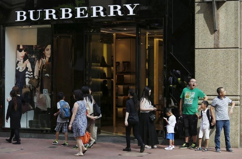 Shoppers wait outside a Burberry store at Causeway Bay shopping district in Hong Kong, China, July 16, 2015. REUTERS/Bobby Yip