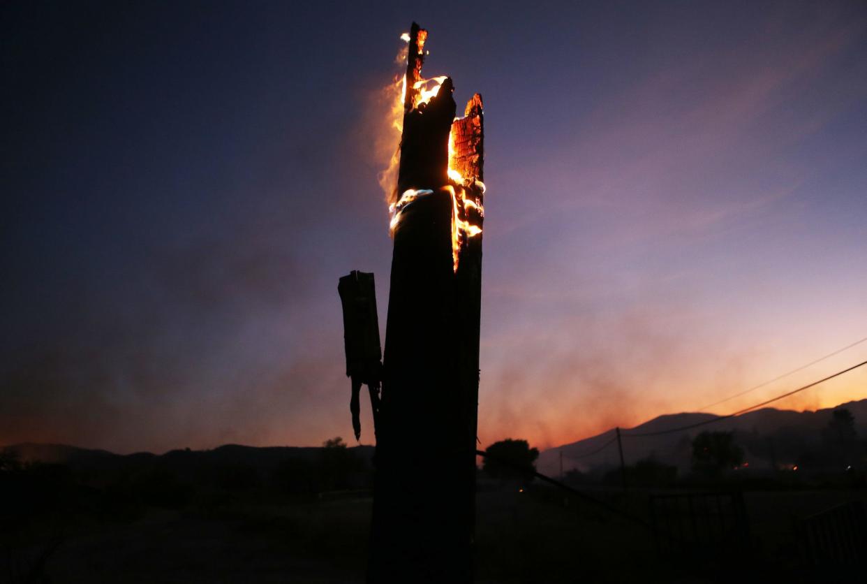 A utility pole burns during the Tick Fire on Oct. 24, 2019 in Canyon Country, Calif.