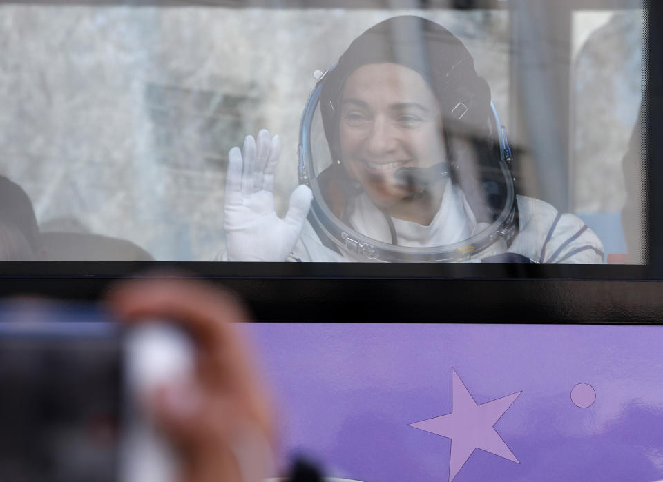 U.S. astronaut Jessica Meir, member of the main crew to the International Space Station (ISS), waves to her relatives from a bus prior the launch of Soyuz-FG rocket at the Russian leased Baikonur cosmodrome, Kazakhstan, Wednesday, Sept. 25, 2019. (AP Photo/Dmitri Lovetsky. Pool)