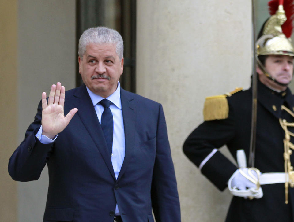 FILE - In this Dec.4, 2014 file photo, Algerian Prime Minister Abdelmalek Sellal waves to reporters as he leaves the Elysee Palace following his meeting with French President Francois Hollande in Paris. Former Algerian Prime Minister Abdelmalek Sellal has been jailed in an anti-corruption sweep — the second former head of government in two days to be sent to prison while his case is investigated. (AP Photo/Remy de la Mauviniere, File)
