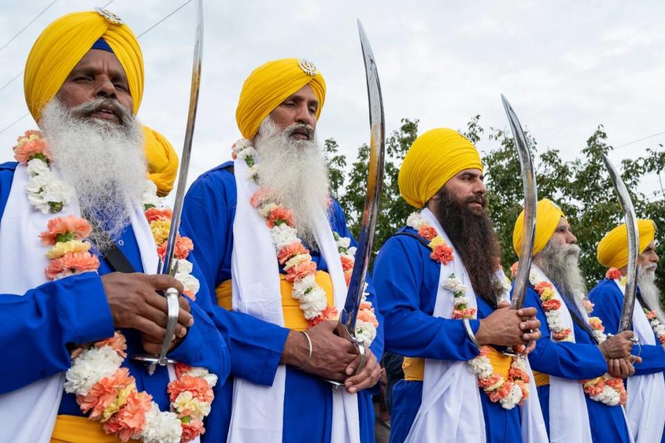 The five men, known as the Panj Pyare, stand in front of the float with the Holy Scripture at the Yuba City Nagar Kirtan Sikh parade on Sunday, Nov. 5, 2023.
