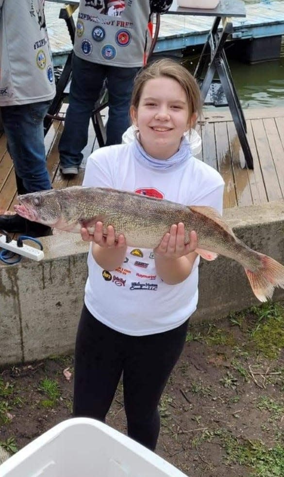 A Monroe youth holds a walleye ready for weigh-in at last year’s Michigan Walleye Tour at the Monroe Boat Club. This weekend, the club is hosting a regional walleye competition, the Masters Walleye Circuit.