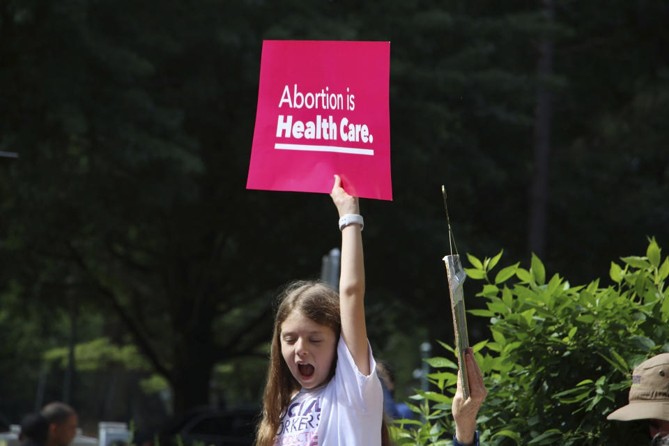 A young girl holds up a sign that reads Abortion is Health Care as she watches North Carolina Democratic Gov. Roy Cooper veto legislation banning most abortions after 12 weeks of pregnancy at a rally in Raleigh, N.C., Saturday, May 13, 2023. (AP Photo/Hannah Schoenbaum)