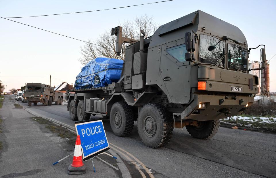 A vehicle of interest wrapped in blue tarpaulin is removed from a road in Salisbury on the back of an army lorry (Picture: PA)