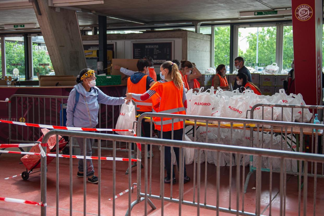 People receive food parcels at a food bank in an ice rink during the coronavirus crisis in Geneva, Switzerland: Getty Images