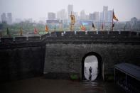 A man walks through an ancient city wall in Jingzhou, after the lockdown was eased in Hubei province