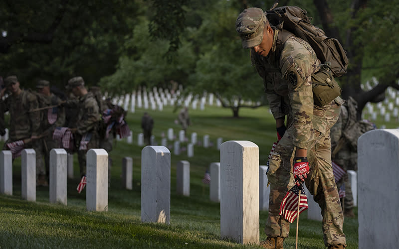 Soldiers from the 3rd U.S. Infantry Regiment place American flags at Arlington National Cemetery