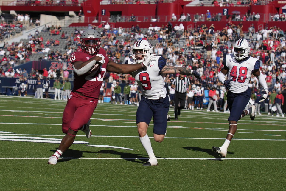 Washington State running back Nakia Watson tries to score a touchdown in front of Arizona safety Gunner Maldonado (9) and linebacker Jerry Roberts in the second half during an NCAA college football game, Saturday, Nov. 19, 2022, in Tucson, Ariz. (AP Photo/Rick Scuteri)