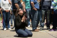 A relative of missing Argentine submarine crew member Celso Oscar Vallejos kneels down to pray, outside Mar del Plata naval base