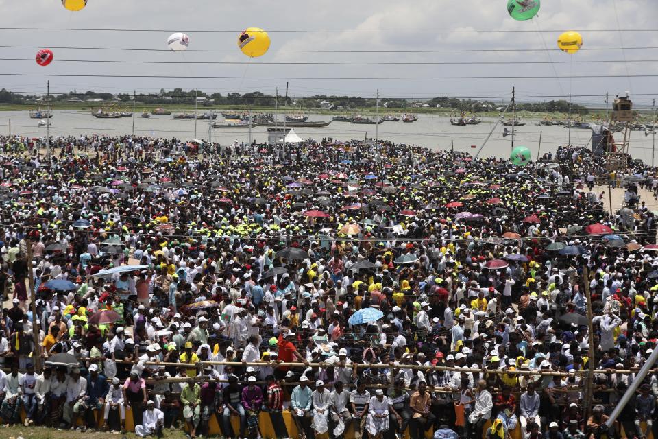 A crowd gathers to watch the opening of Bangladesh's longest bridge, which took eight years to build amid setbacks involving political conflict and corruption allegations, over Padma River on the outskirts of Dhaka, Bangladesh, Saturday, June 25, 2022. The 6.51-kilometer (4.04-mile) bridge cost an estimated $3.6 billion and was paid for with domestic funds after the World Bank and other global lending agencies declined to finance the project following a graft scandal involving a Canadian construction company linked to the bridge. (AP Photo/Mahmud Hossain Opu)