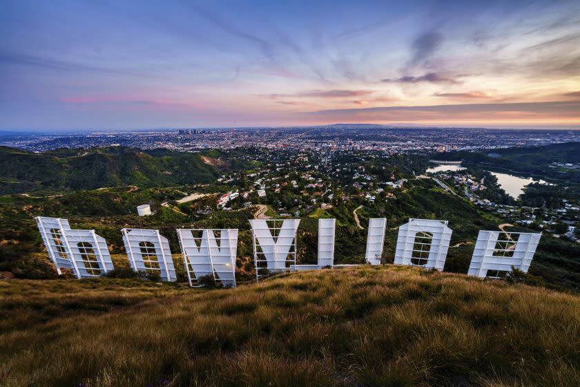 Sunset casts a pink glow over the Los Angeles skyline as seen from behind the famous Hollywood sign Wednesday evening, March 8, 2023. The 95th annual Academy Awards will be held Sunday at the Dolby Theatre in the Hollywood section of Los Angeles. (AP Photo/J. David Ake)