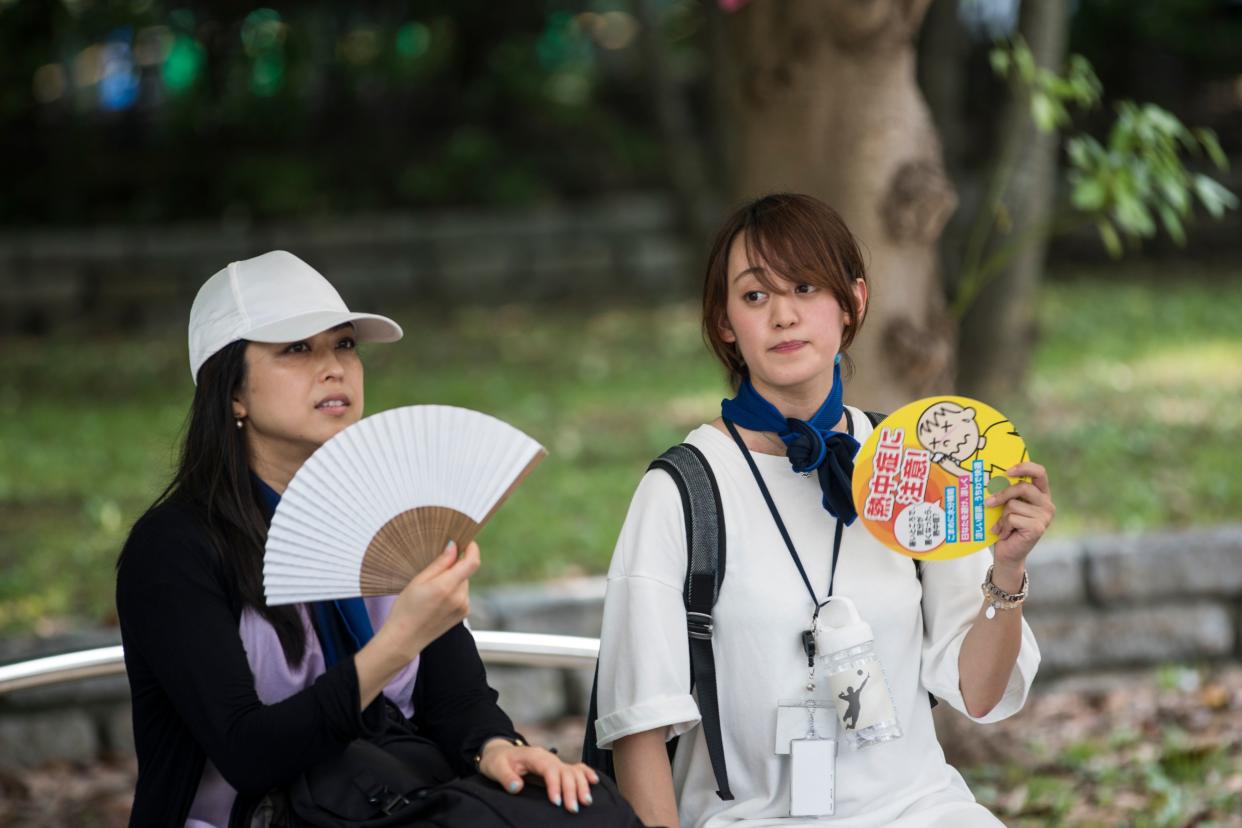 People use hand fans to cool off during the beach volleyball Tokyo 2020 Olympic Games test event at Shiokaze park in Tokyo on July 25, 2019. - Tokyo 2020 Olympics organisers tested everything from misting sprays to air-conditioned tents on July 25 as they trialed heat mitigation measures a year before the Games gets under way. (Photo by Behrouz MEHRI / AFP)        (Photo credit should read BEHROUZ MEHRI/AFP/Getty Images)