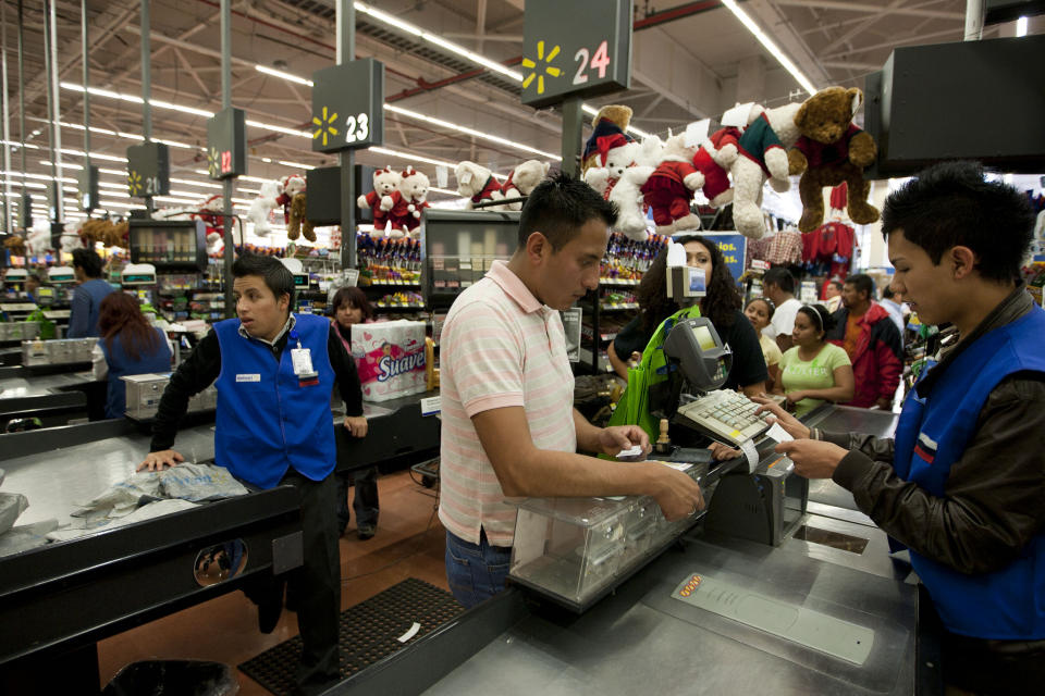 In this Nov. 18, 2011 photo, a man pays at the cash register at a Wal-Mart Superstore in Mexico City. Wal-Mart Stores Inc. hushed up a vast bribery campaign that top executives of its Mexican subsidiary carried out to build stores across Mexico, according to a published report by the New York Times. (AP Photo)