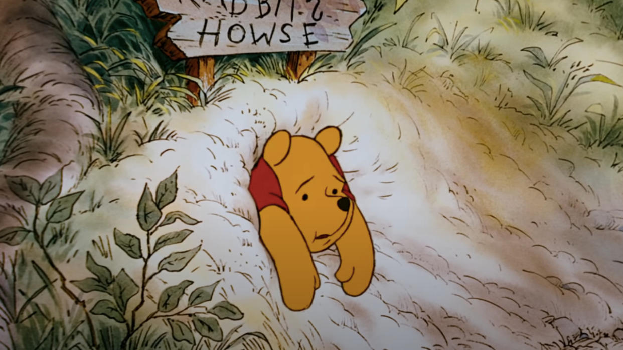  Winnie The Pooh sitting stuck in Rabbit's front door in The Many Adventures of Winnie the Pooh. 