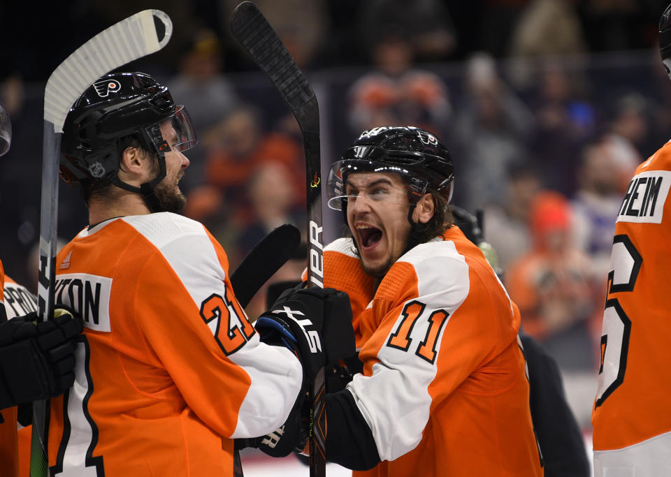 Philadelphia Flyers' Travis Konecny, right, celebrates with Scott Laughton after a victory in a shootout during an NHL hockey game against the Boston Bruins, Monday, Jan. 13, 2020, in Philadelphia. The Flyers won 6-5. (AP Photo/Derik Hamilton)