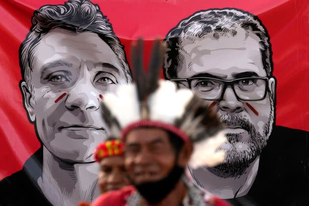 Indigenous men stand in front of images of slain British journalist Dom Phillips, left, and slain Indigenous expert Bruno Pereira in Brasilia, Brazil, on June 23. (Photo: Eraldo Peres/Associated Press)