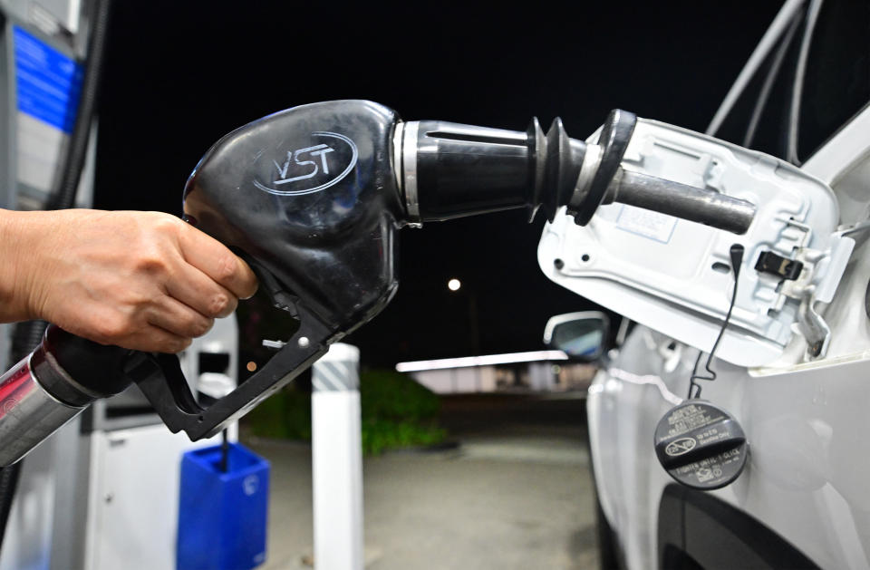 A person holds a nozzle as they fill up their tank at a gas station in La Puente, California, on September 7, 2023.